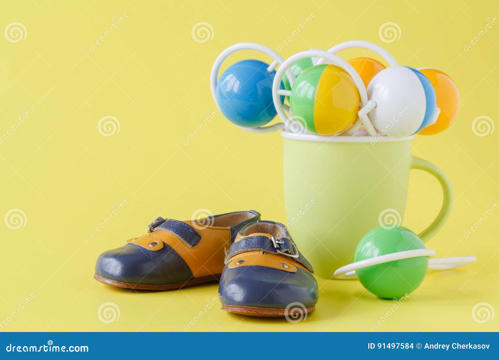 Baby Rattle and Booties on Yellow Background Stock Photo Image of