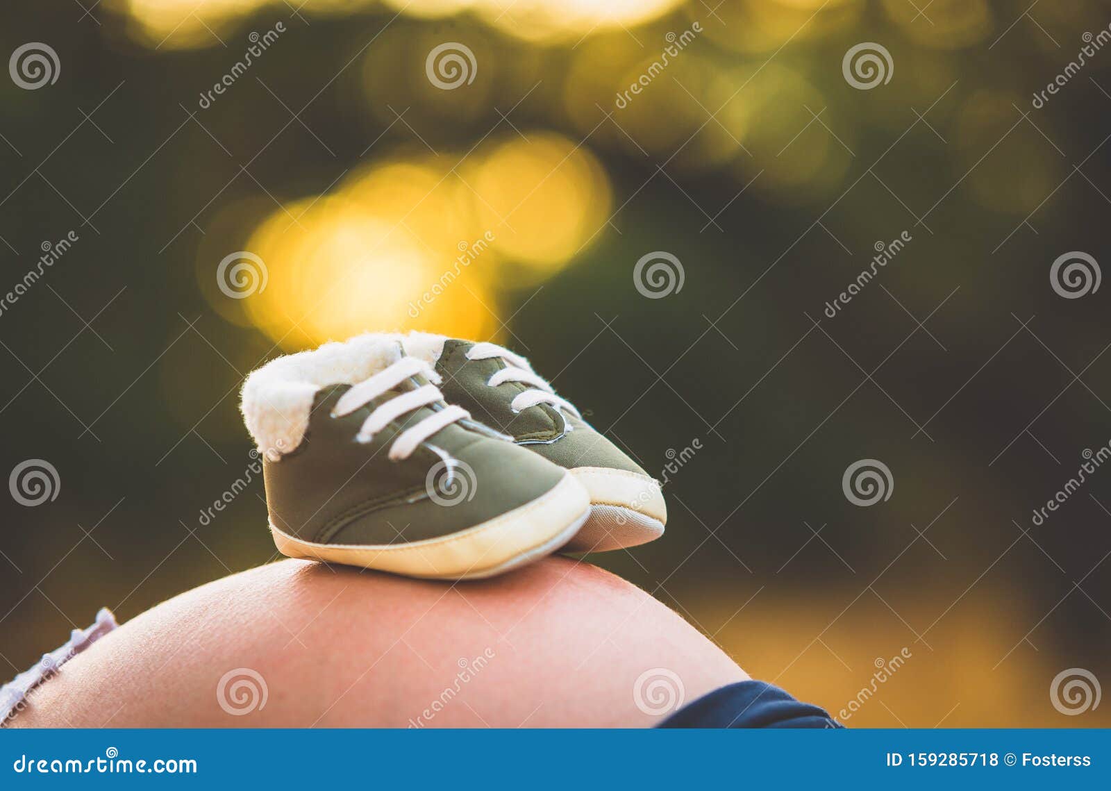 baby shoes on top of a pregnant woman