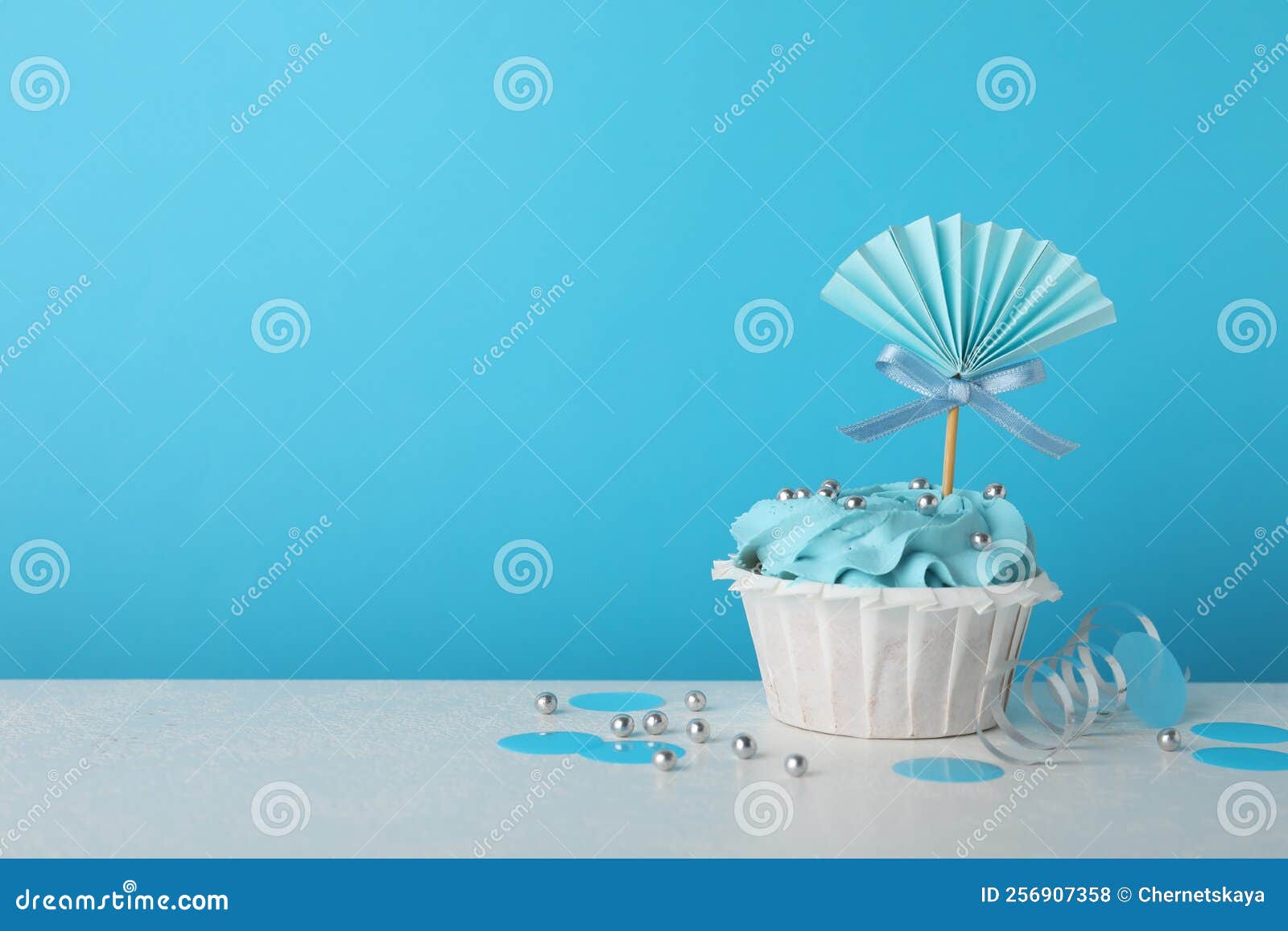 Baby Shower Cupcake with Topper on White Table Against Light Blue