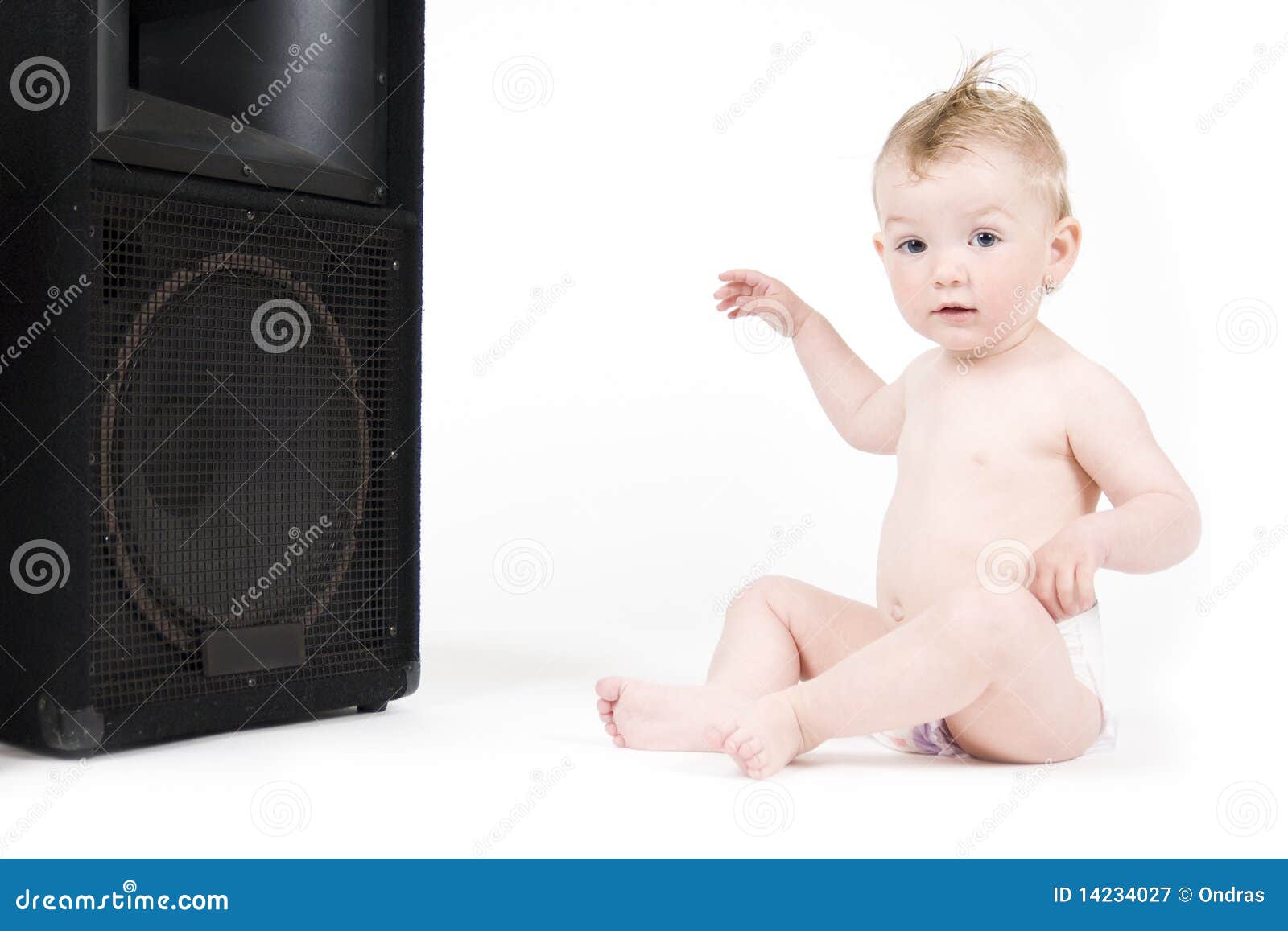 baby sitting in front of loudspeaker
