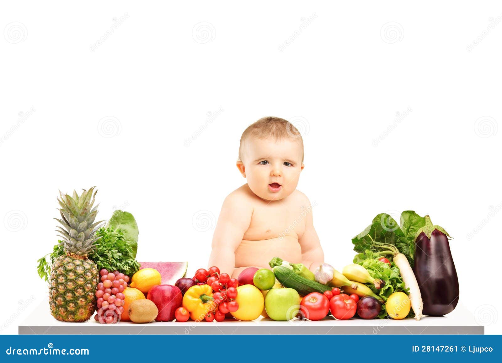 Baby Sitting On A Table Full Of Different Fruits And Vegetables Stock