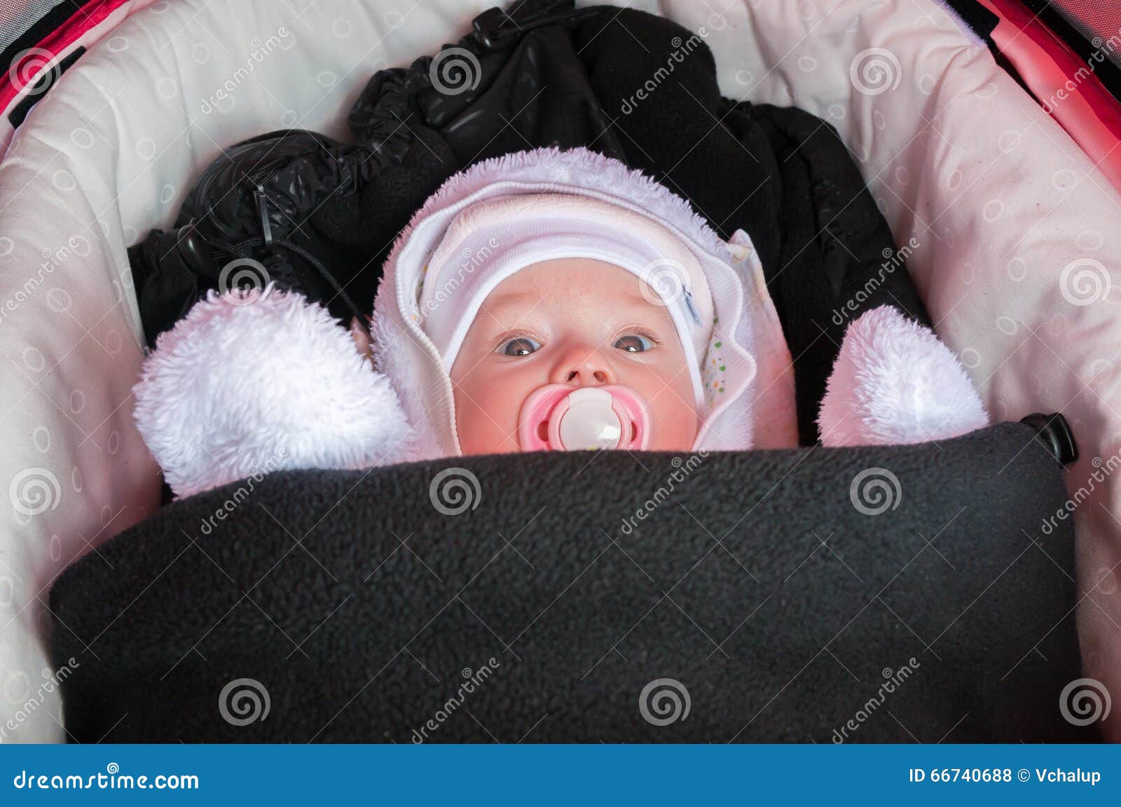 baby in stroller is dressed and warmly wrapped in freezing winter