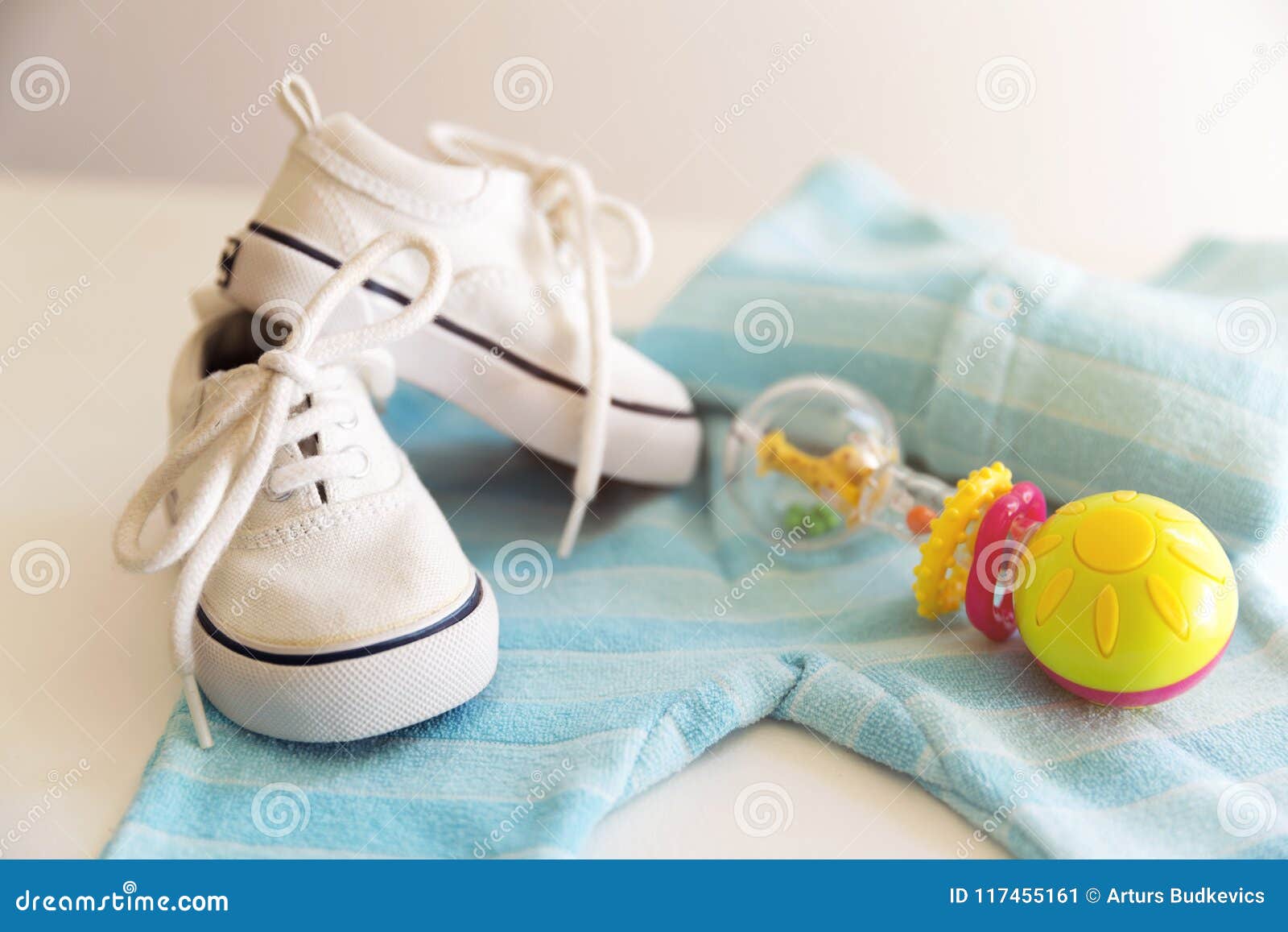 baby stuff is on a white background. things for little boy, rattle and shoes. newborn baby necessities.