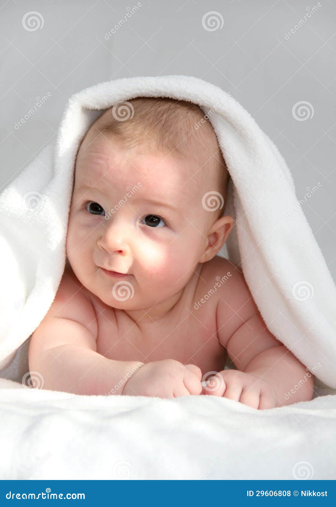 Happy Baby Under Blanket With Blue Eyes On White 