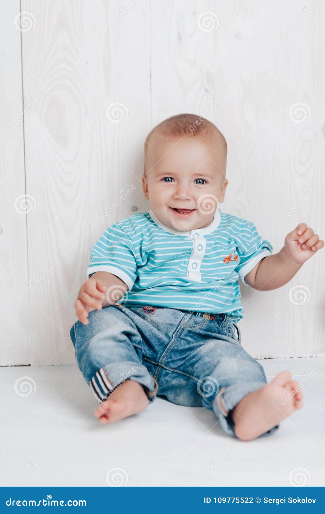 Baby is Very Cute Smiling Sitting on the Floor Against a Light ...