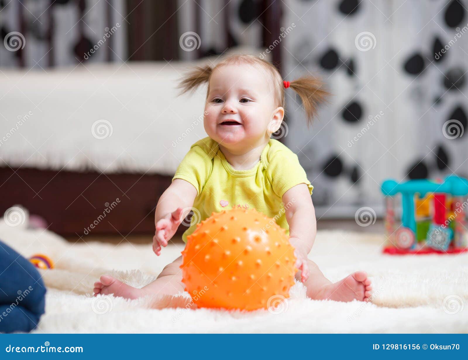 Babyhood And People Concept Happy Baby Playing With Ball On Floor At Babyhood And People Concept Happy Baby Playing With Ball On Floor At
