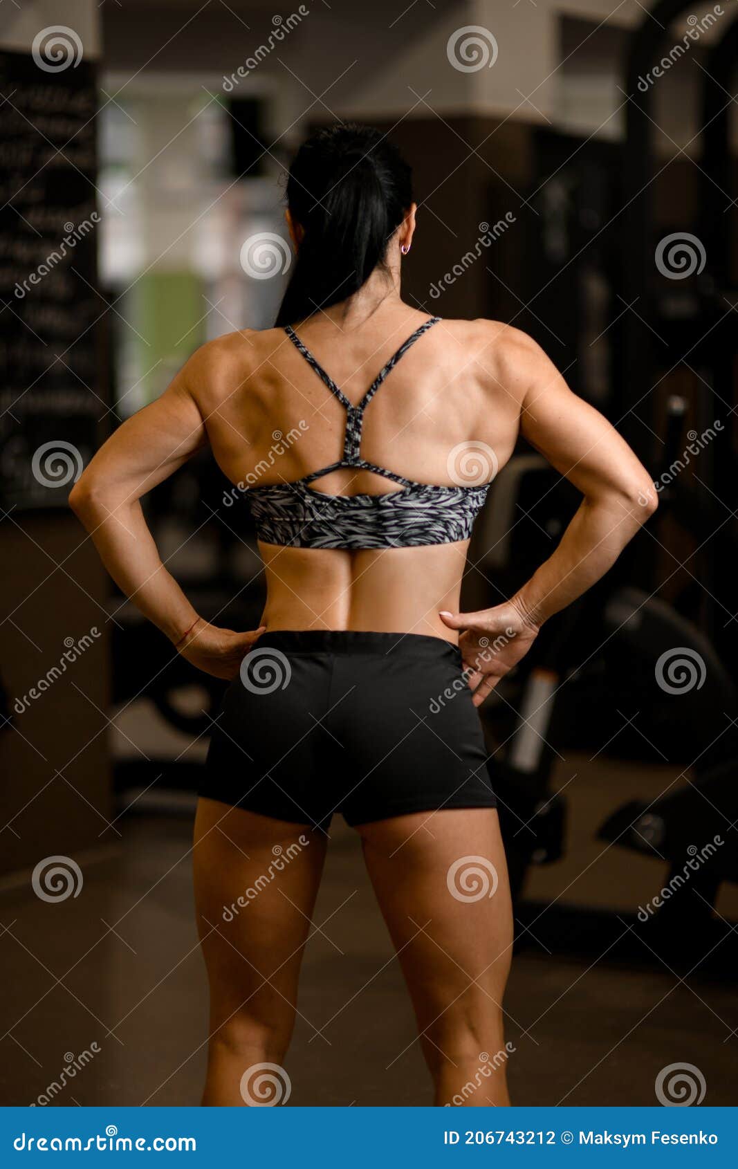 Back View of Healthy Strong Woman in Sportswear Standing in Gym