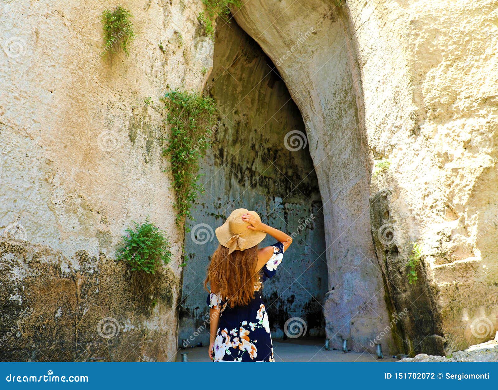back view of beautiful woman comes into the ear of dionysius orecchio di dionisio in syracuse, sicily, italy