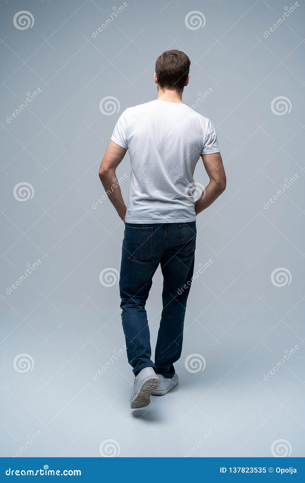 Back View of a Casual Young Man Walking and Looking To Side on Gray  Background. Stock Image - Image of happy, adult: 137823535