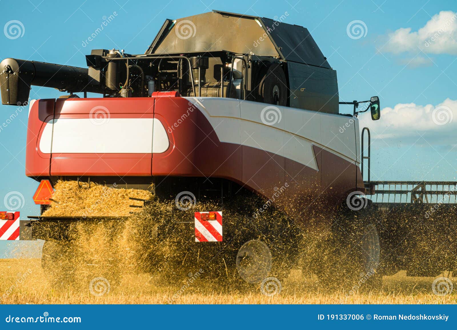 back view of combine harvester at work in field