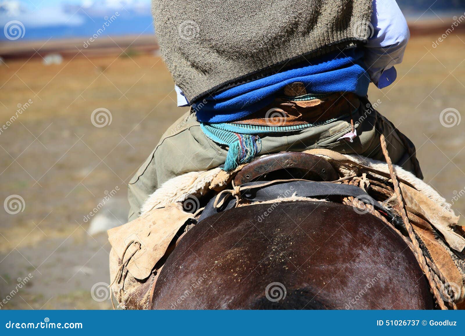 back view of gaucho riding horse in argentina