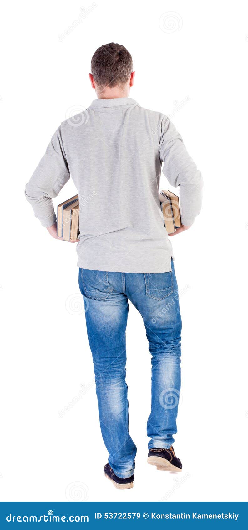 back view of going handsome man carries a stack of books.