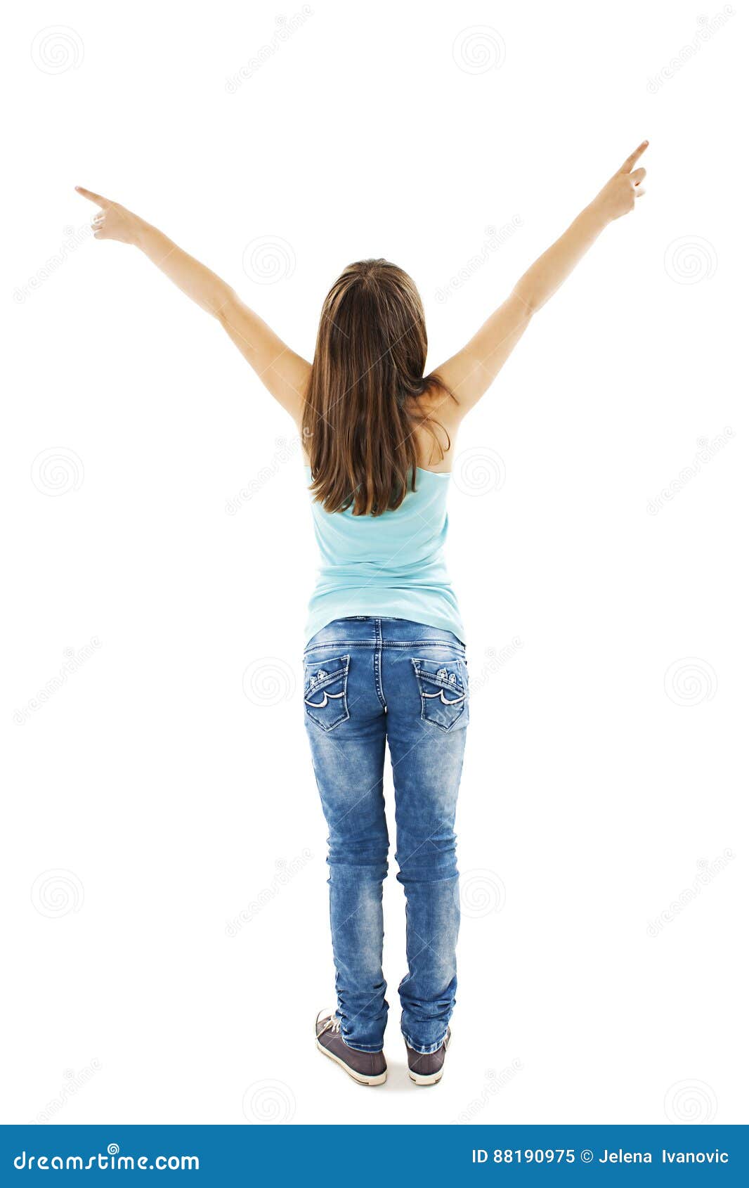 back view of little girl points at wall with both hands. rear view