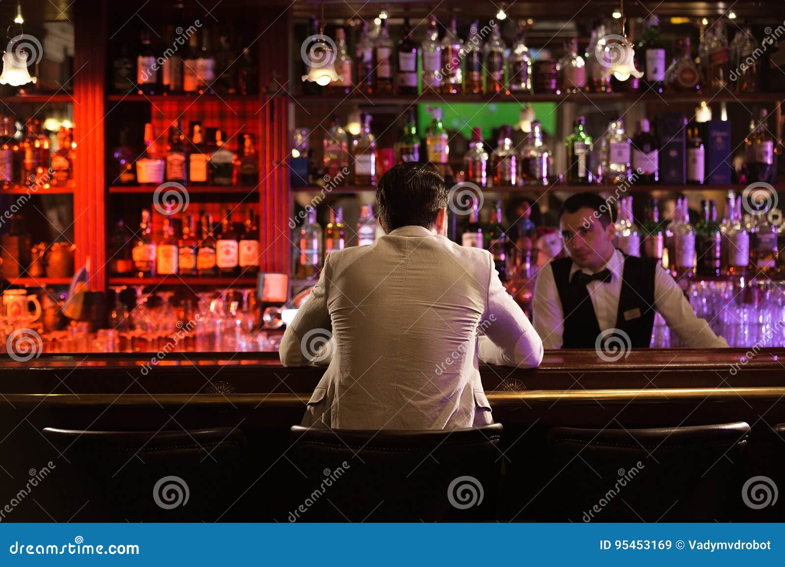 back view of a man ordering drink to a bartender