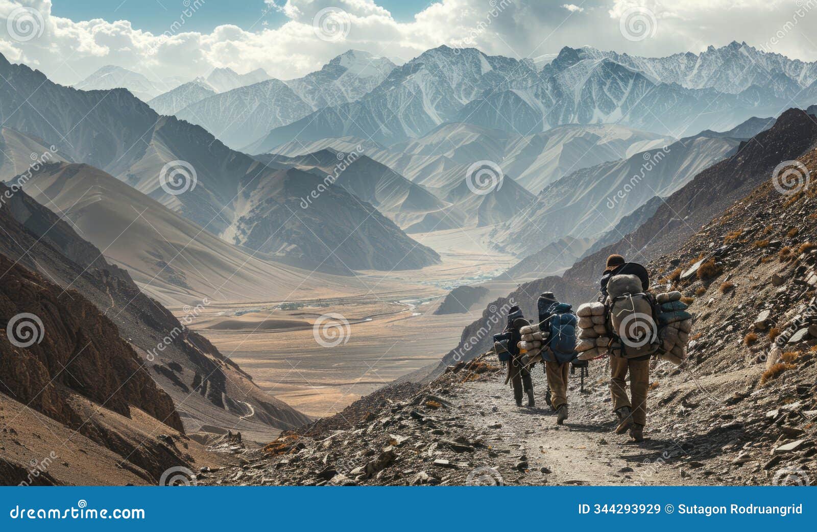 back view of mountain nomads people traversing mountain range