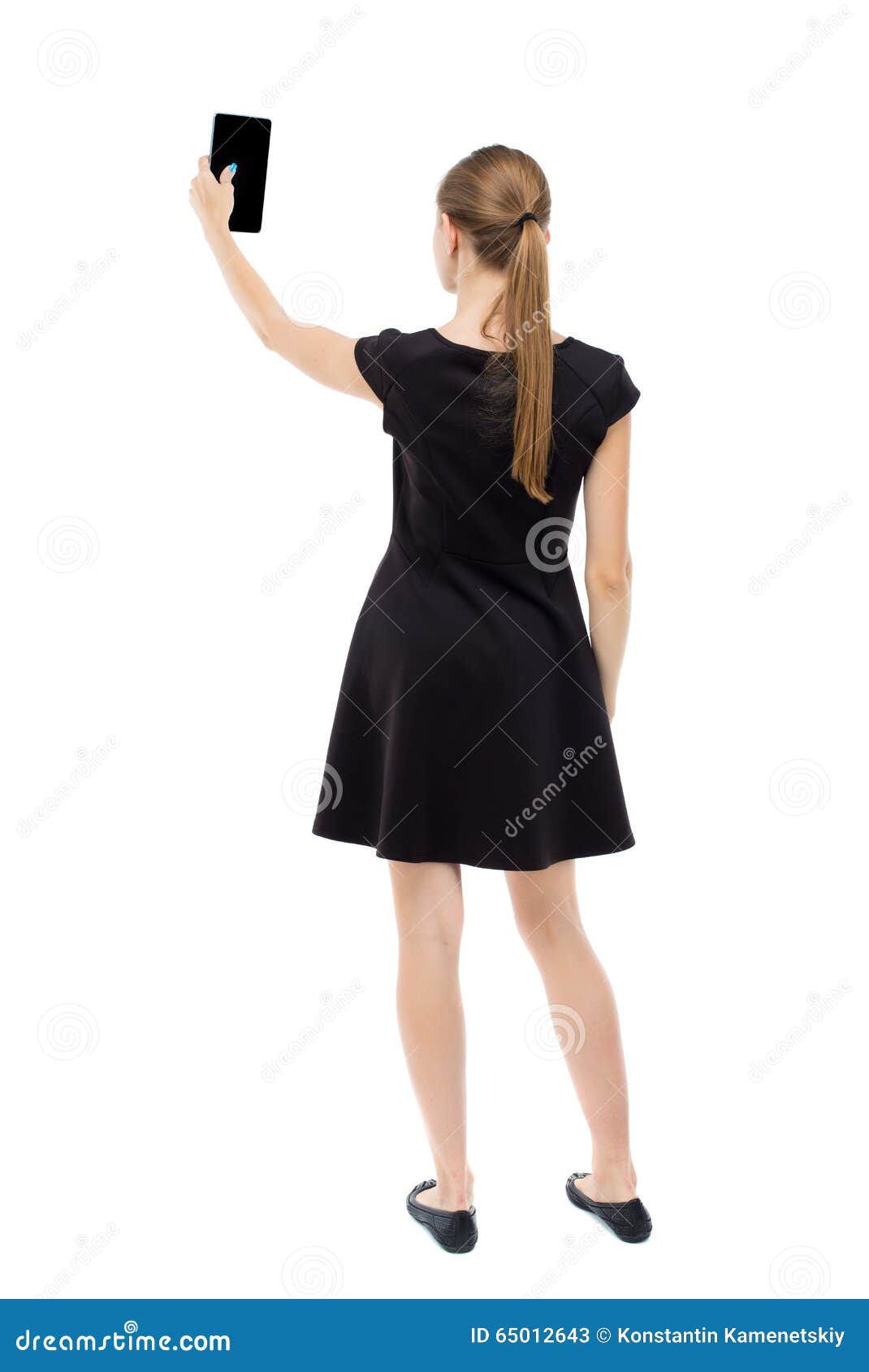 back view of standing young beautiful girl with tablet computer