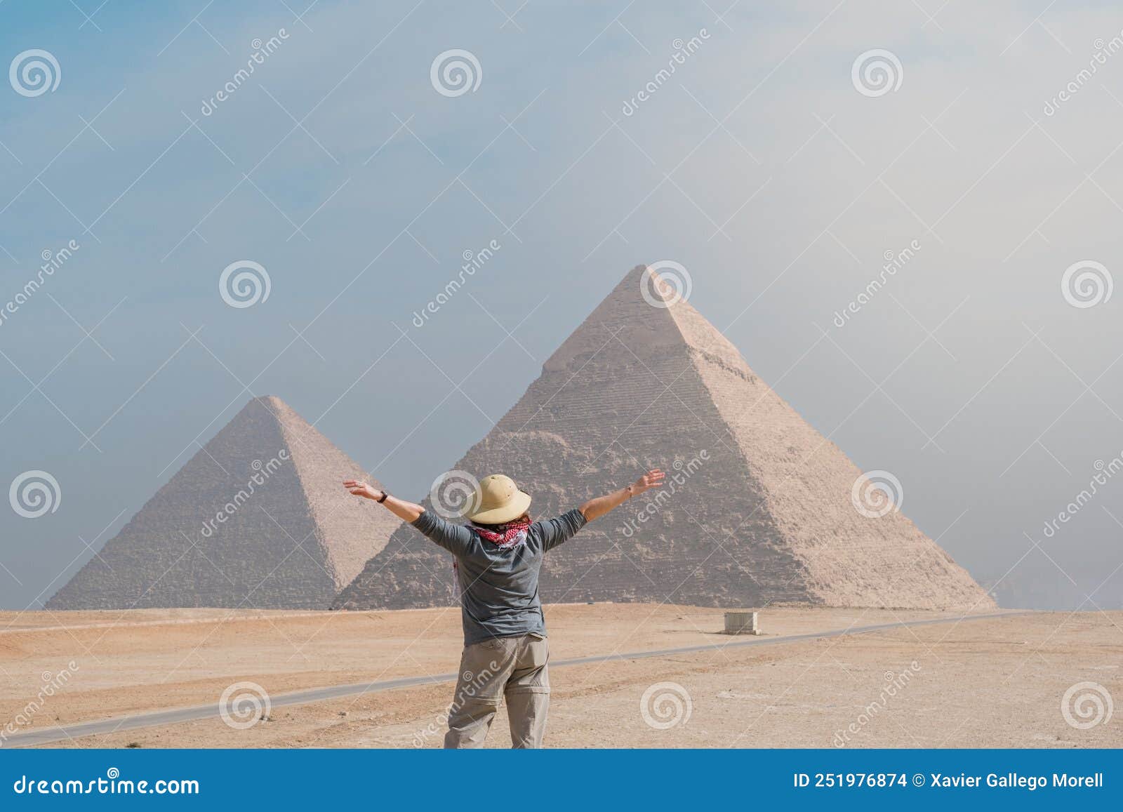 back view of tourist woman standing in front of pyramids. egypt, cairo - giza