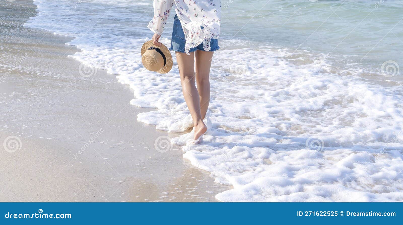 Back View Of Woman S Legs Walking On Sandy Beach Near Turquoise Colored