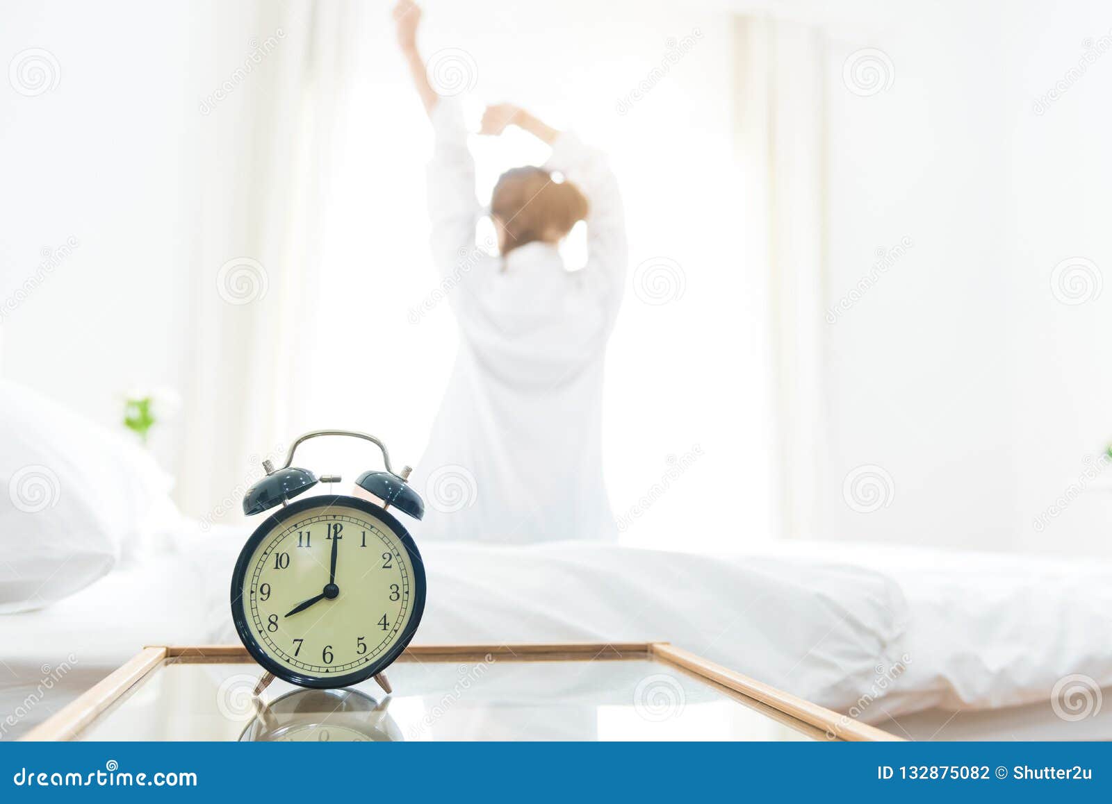 back view of woman stretching in morning after waking up on bed