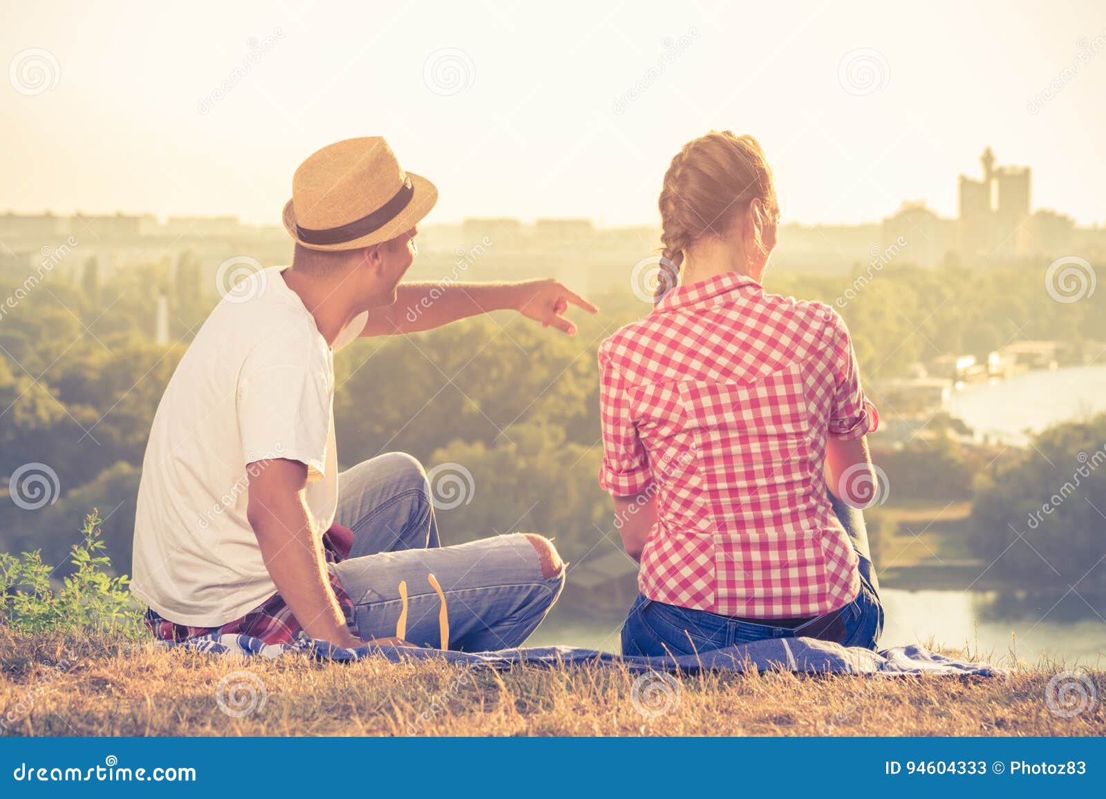 Back coupling. Couple back view. Lovers sitting at Home back view. Man sits on Hills and looks on City. Western couple back view.