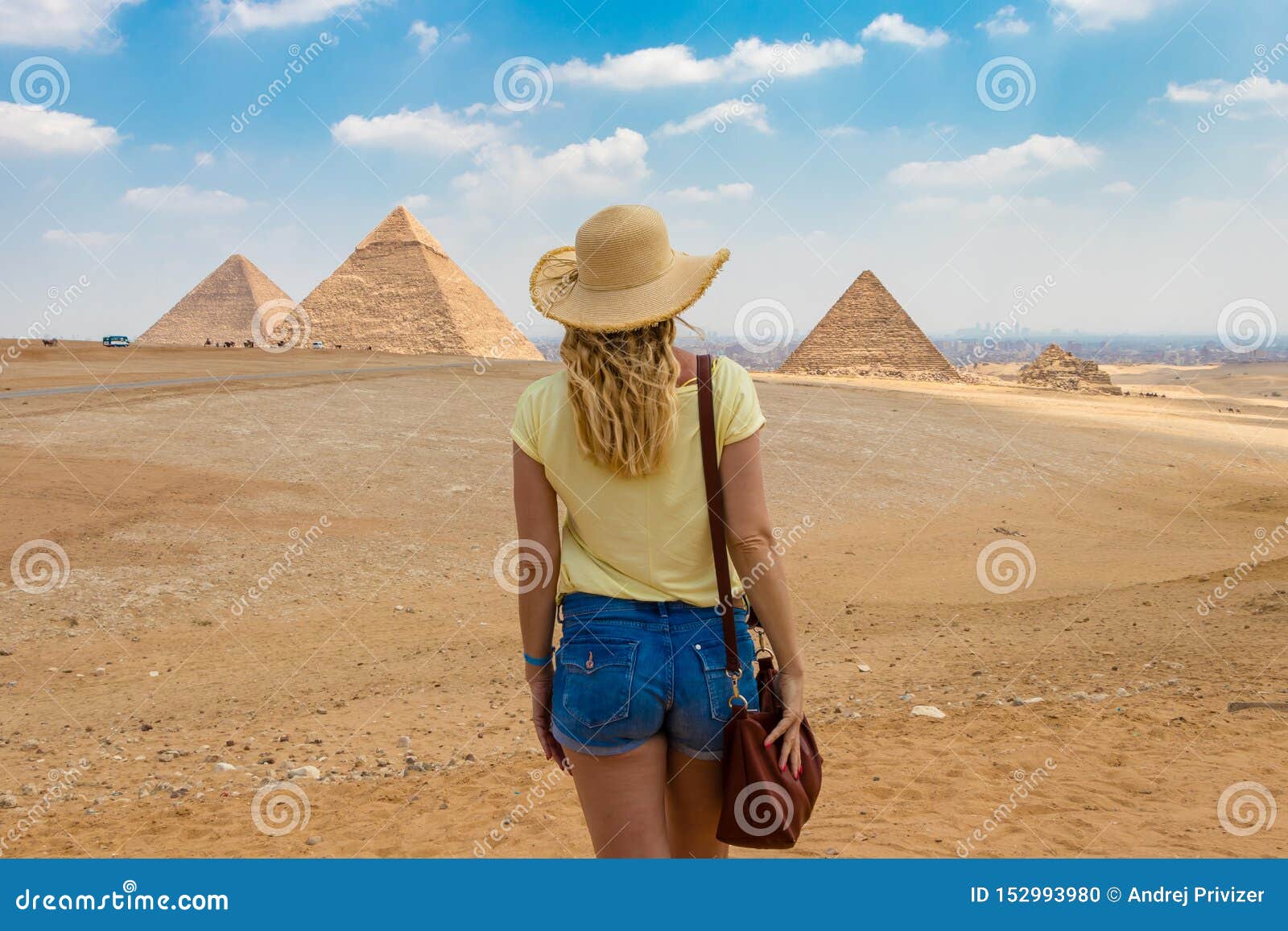 back view of the young female watching the great pyramids of giza in egypt