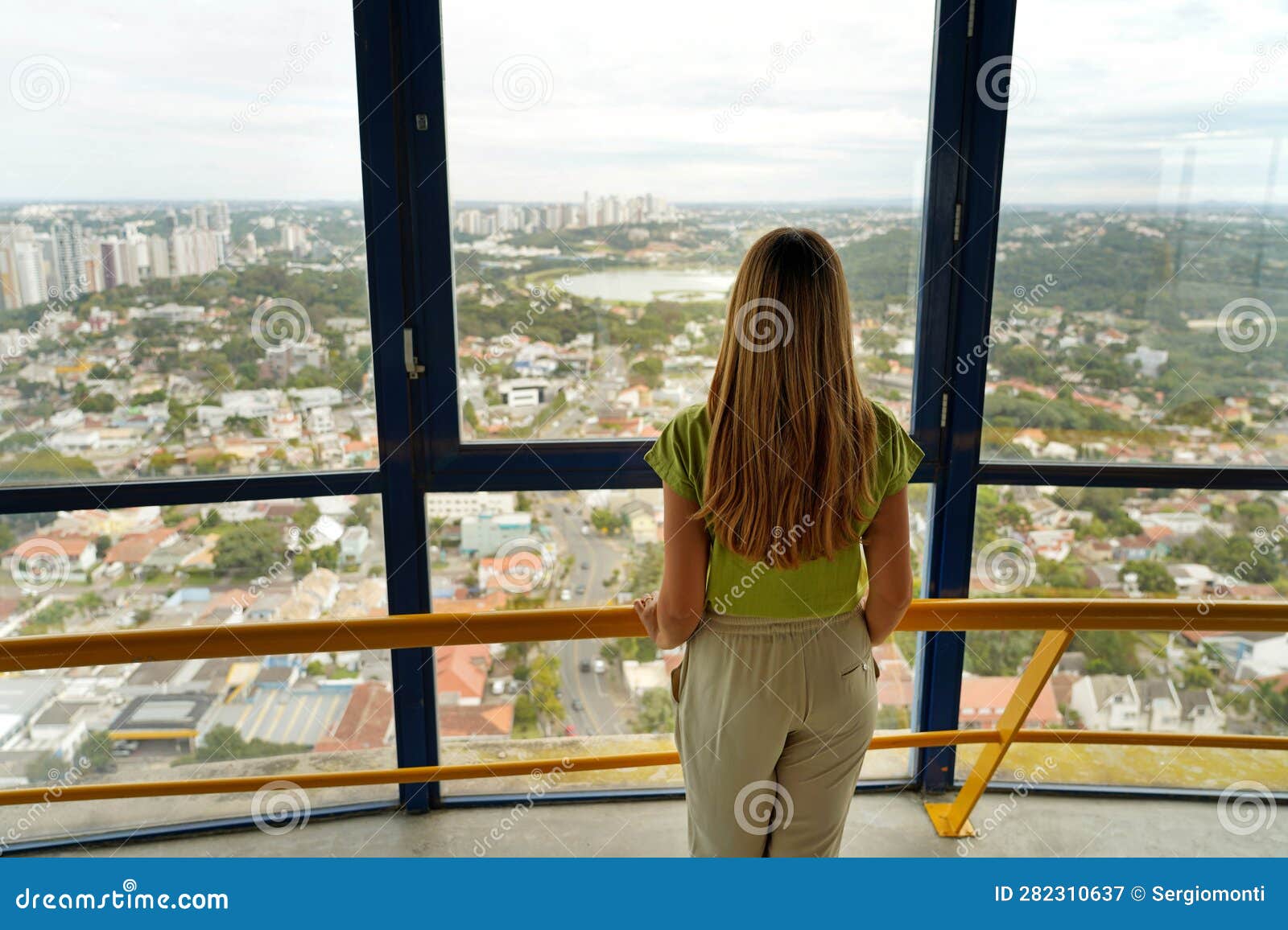 back view of young woman looking curitiba cityscape from torre panoramica the panoramic tower of curitiba, parana, brazil