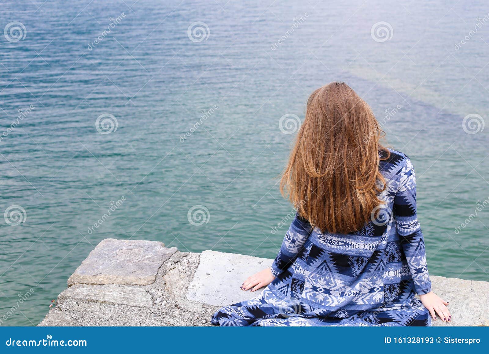 Back View of Young Woman Sitting Near Lake Como, Water in Background ...