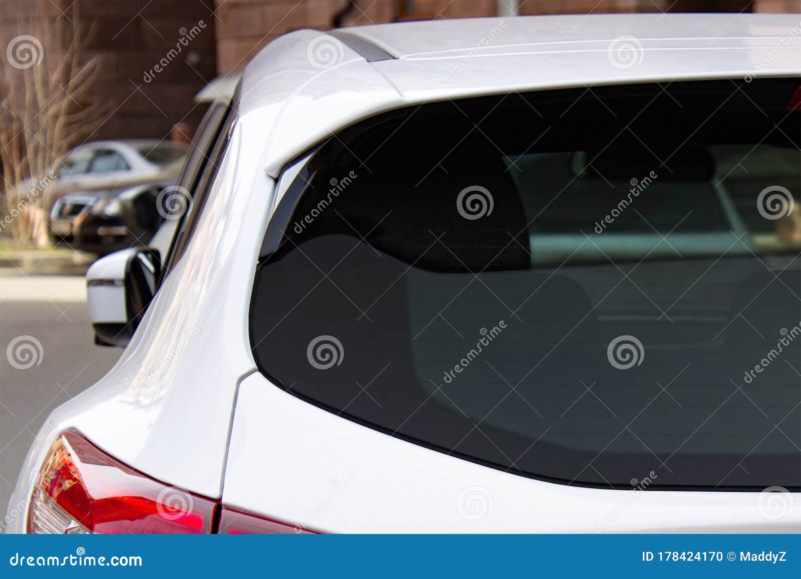 back window of a white car parked on the street, rear view. mock-up for sticker or decals
