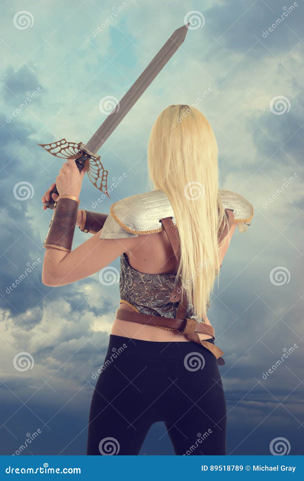 back of woman warrior holding a sword