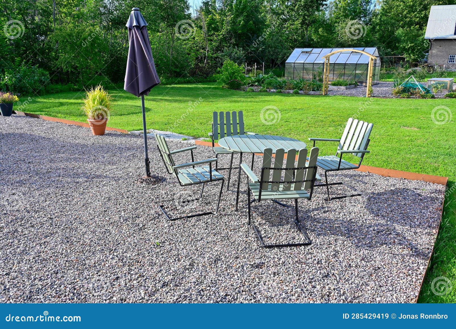 Back Yard with Seating Area on Gravel and Lawn Around Stock Image