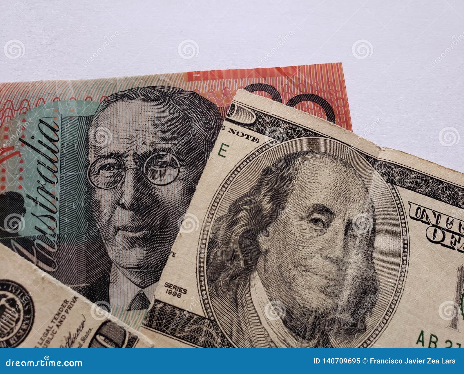 australian banknote of twenty dollars and broken american banknote of 100 dollars