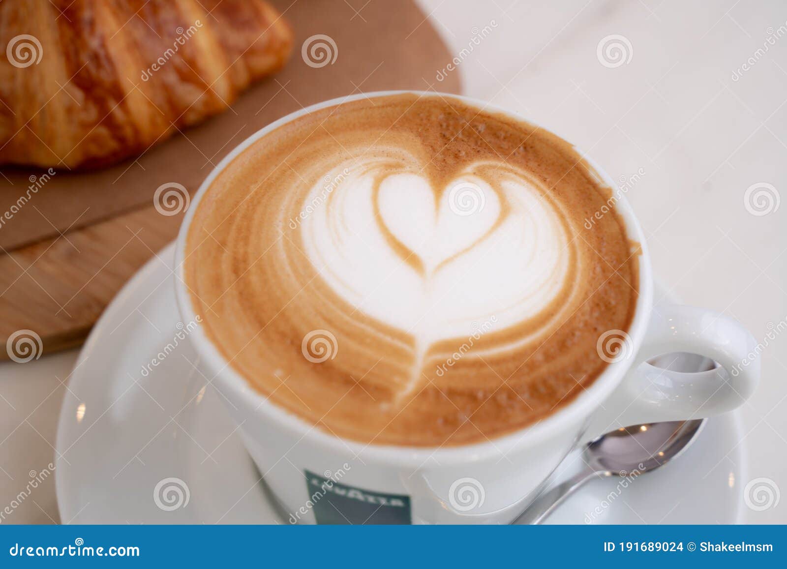 Background Image of Cappuccino in Lavazza Cup with Croissant Editorial