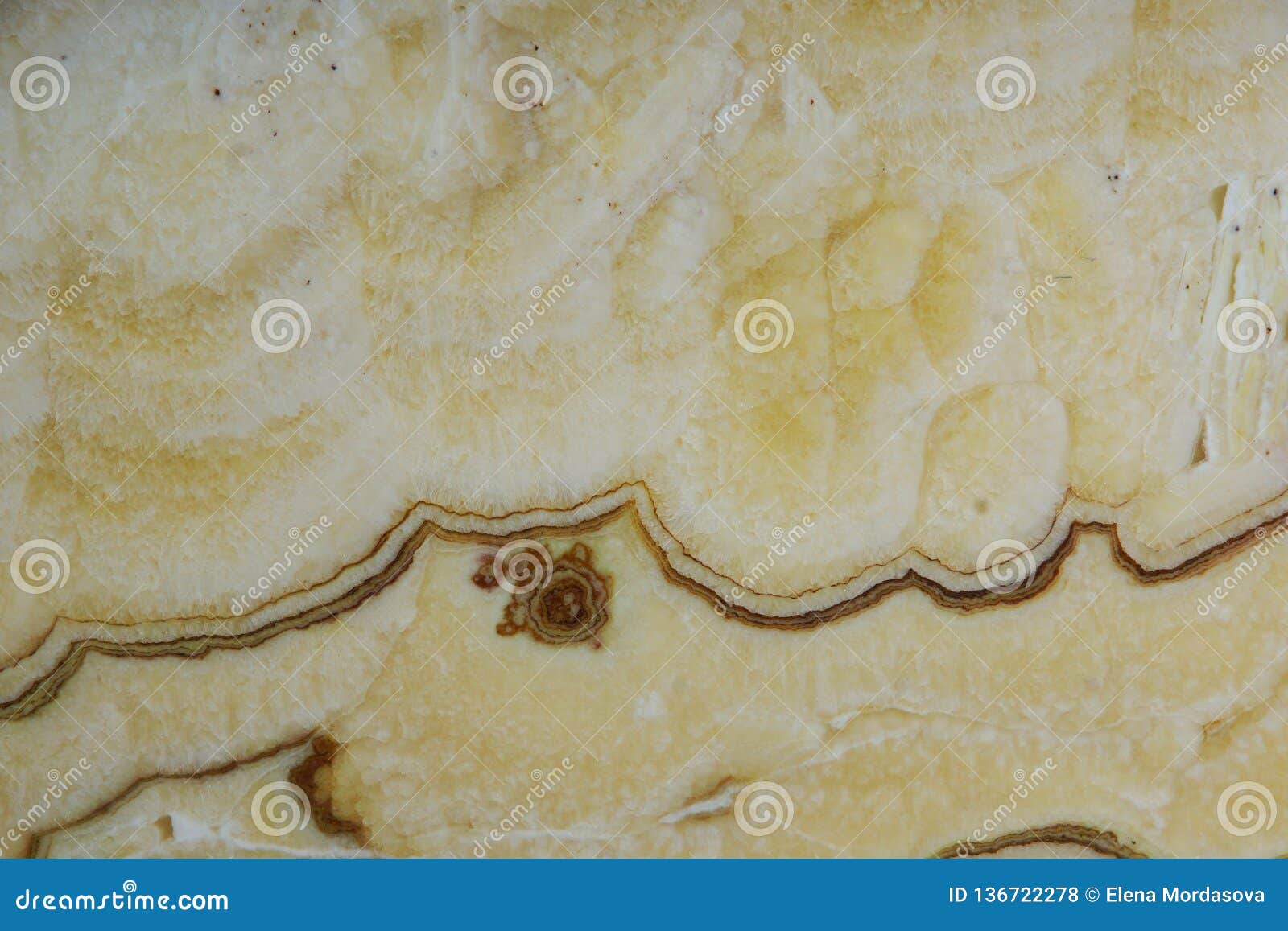 background from a light yellow natural stone onyx with bubbles and stains on the surface is called onice arco iris