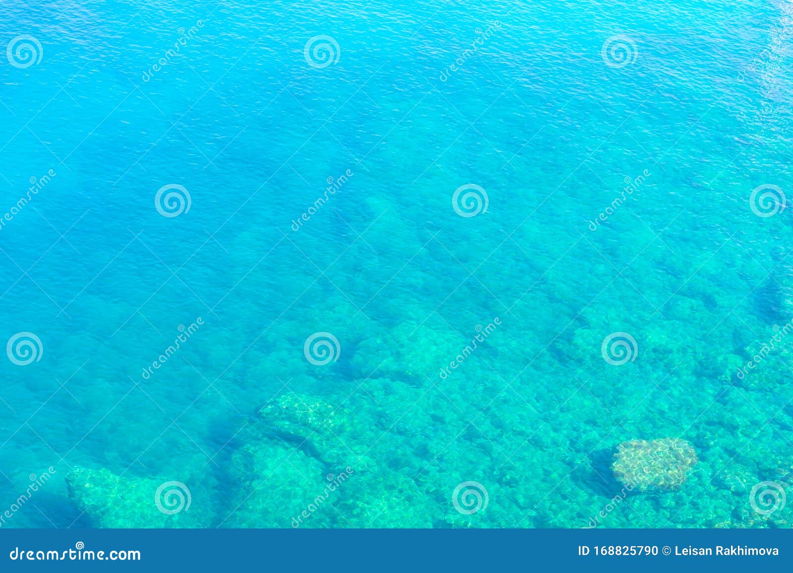 background made of clean transparent blue water sea surface. mediterranian sea surface on sunny day with waves and flares.