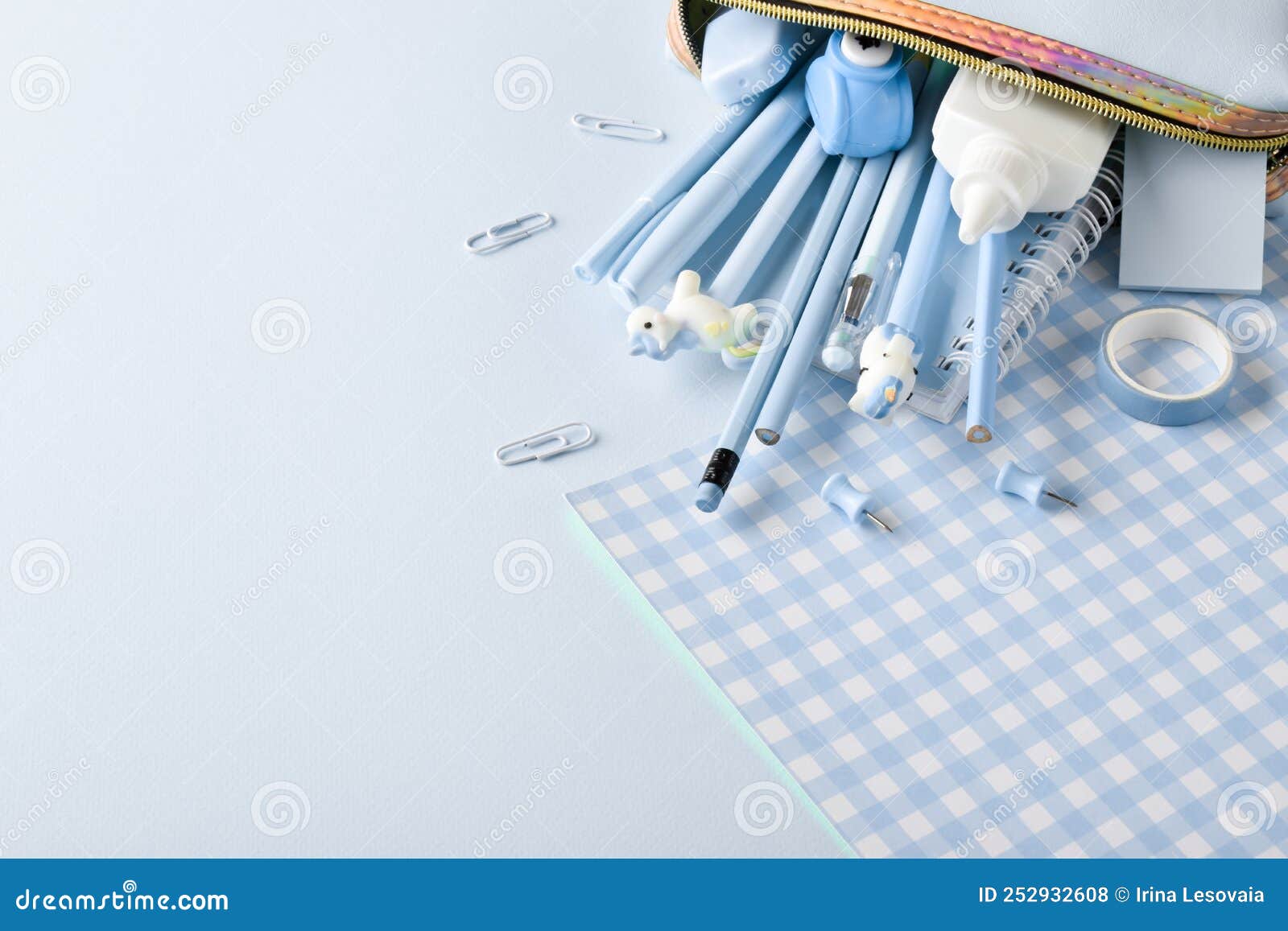 Background with Pencil Case and Various Blue Stationery on a Light Blue