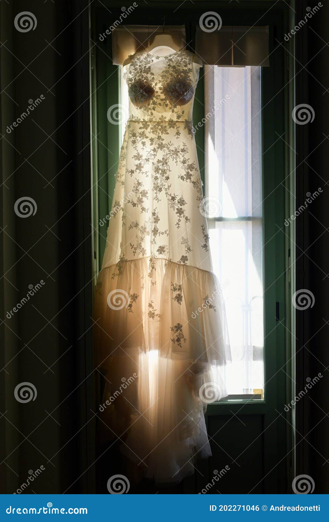 Backlit Elegant Wedding Dress Hanging in a Window Stock Photo - Image ...