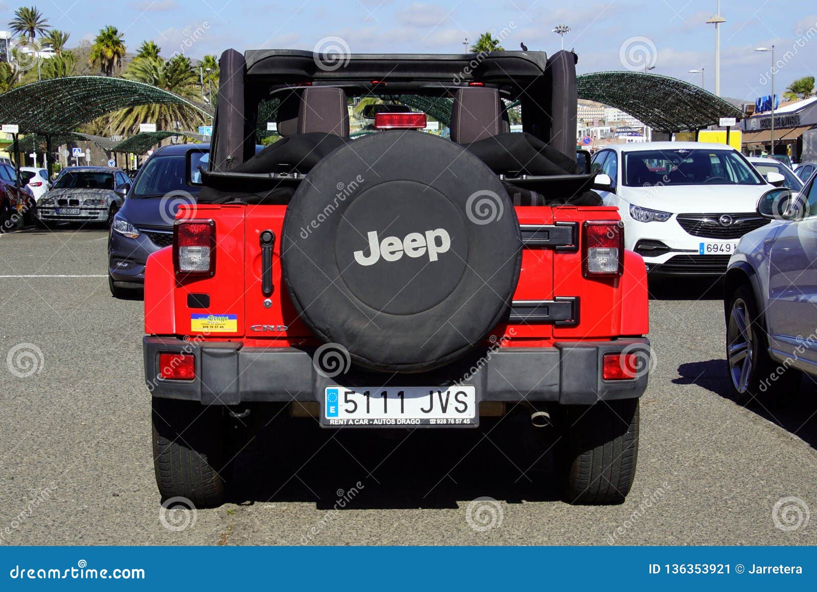 A red jeep parked in front of a louis vuitton store photo – Free