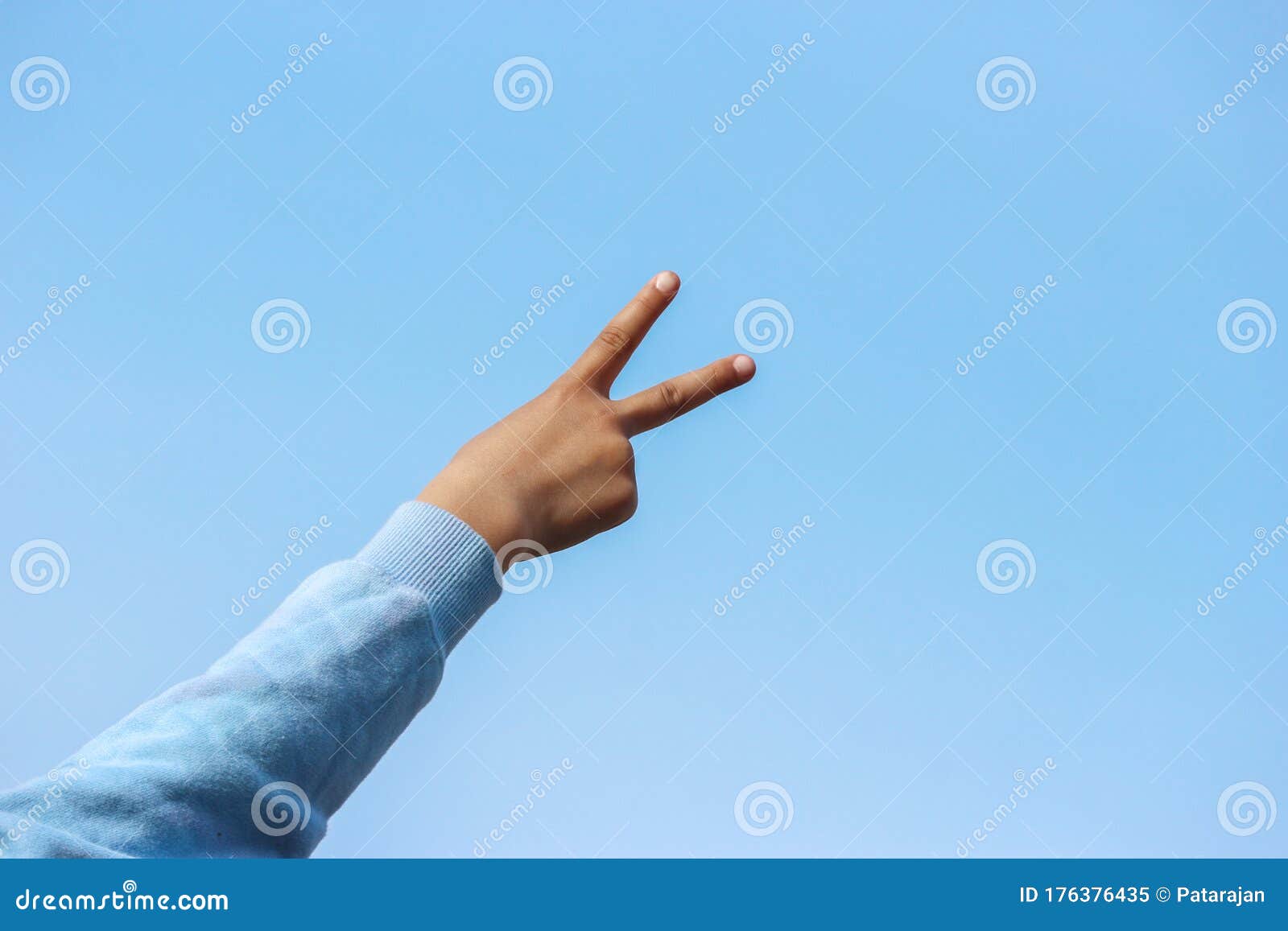 Backside of a Victory Sign from a Young Girl Hand with Blue Sky As  Background. Stock Image - Image of background, language: 176376435