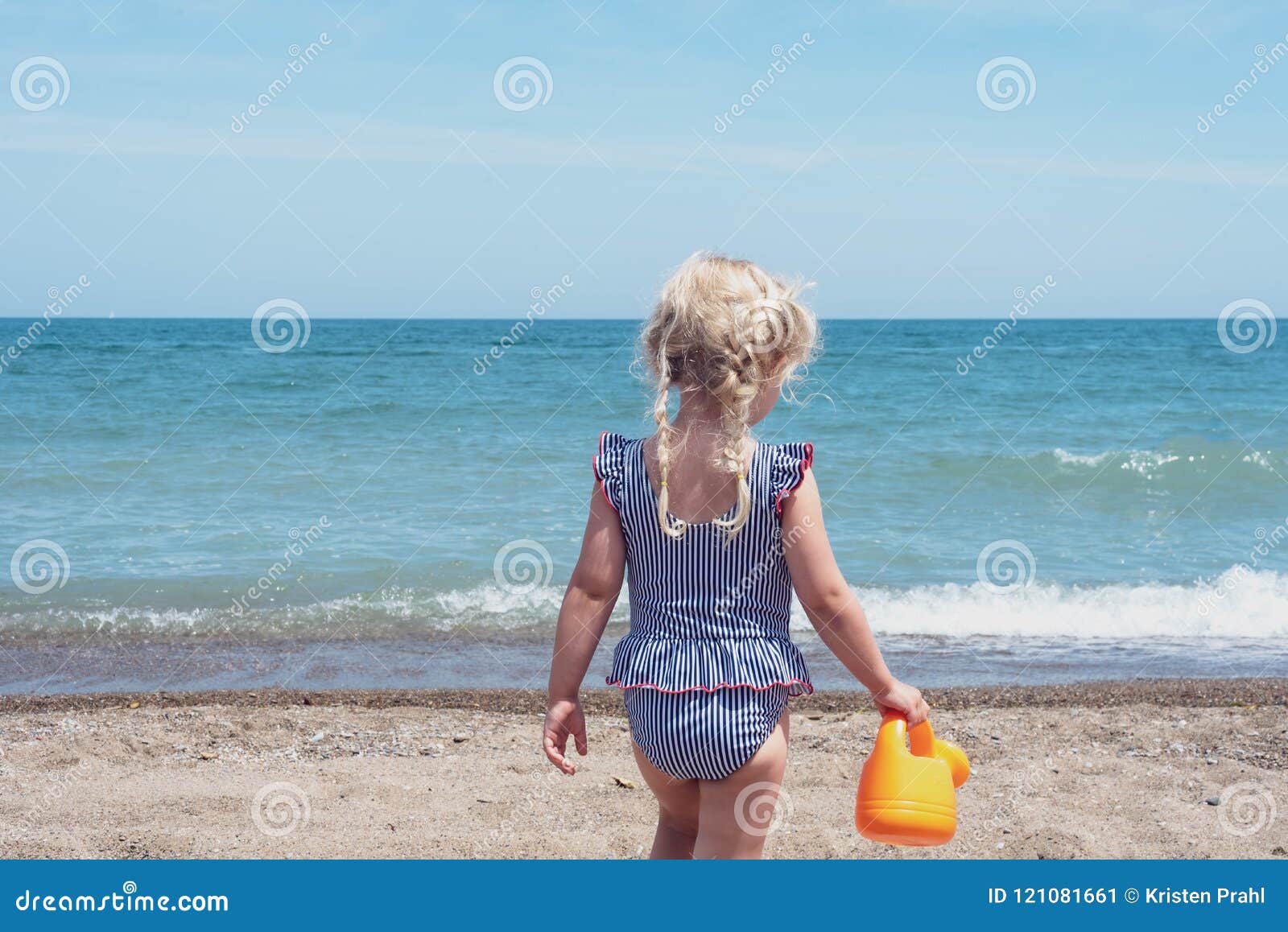 backview of little girl playing at the beach
