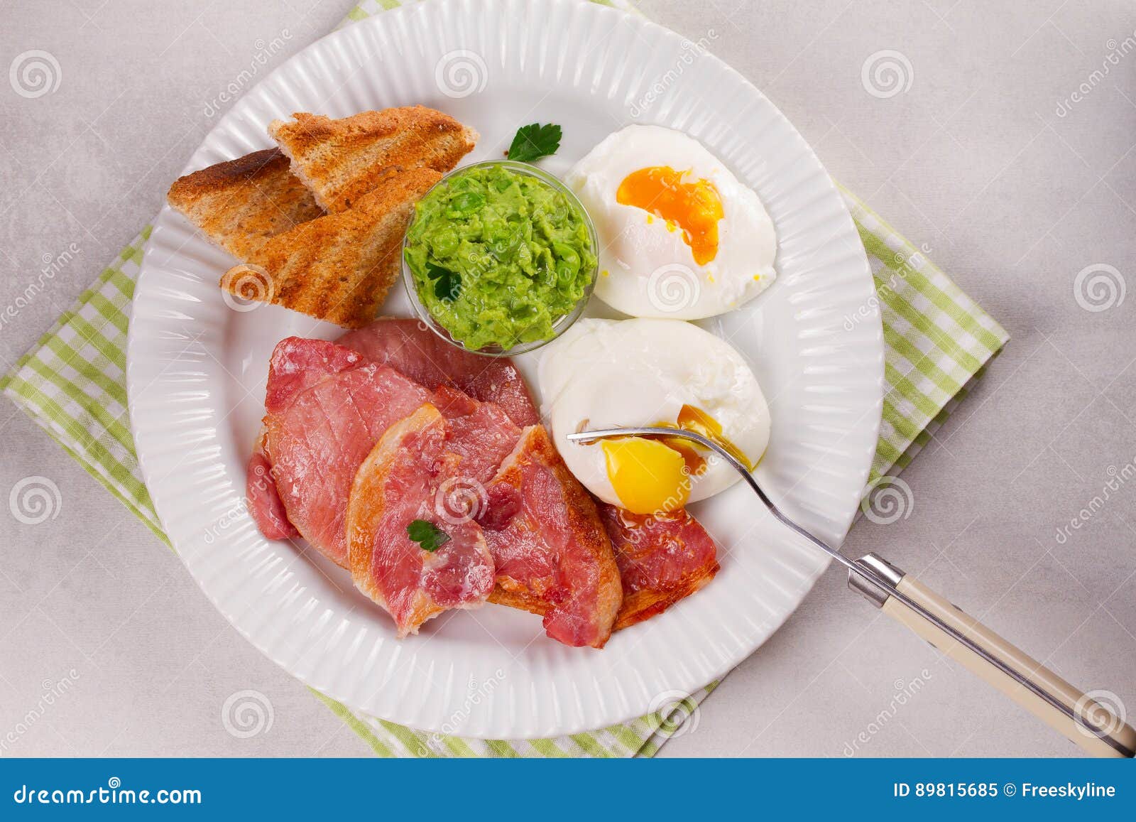 Bacon, Poached Eggs, Mashed Peas and Toasts on White Plate. Grilled