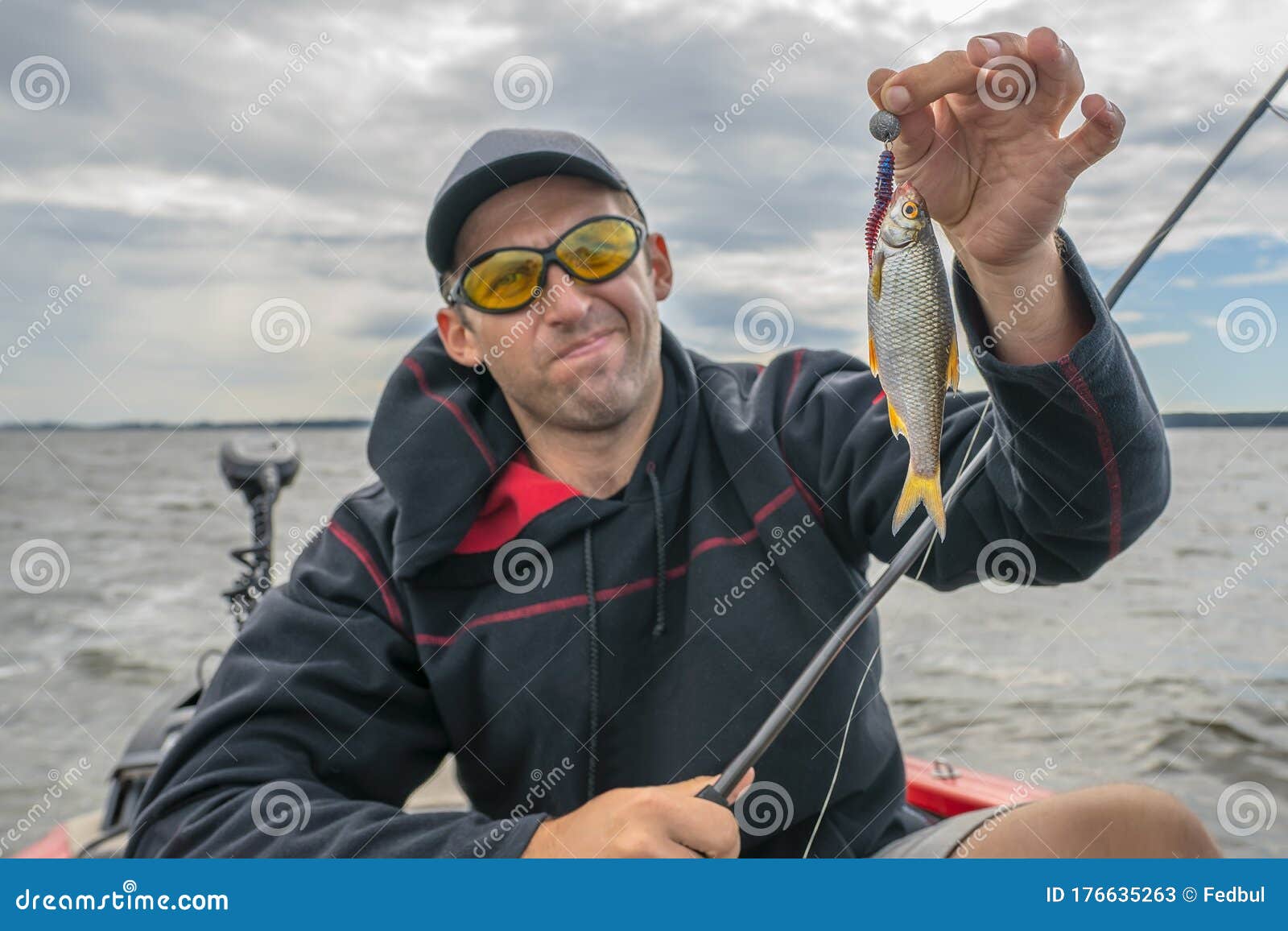 Bad Fishing. Upset Fisherman with Small Fish in Hand Stock Image