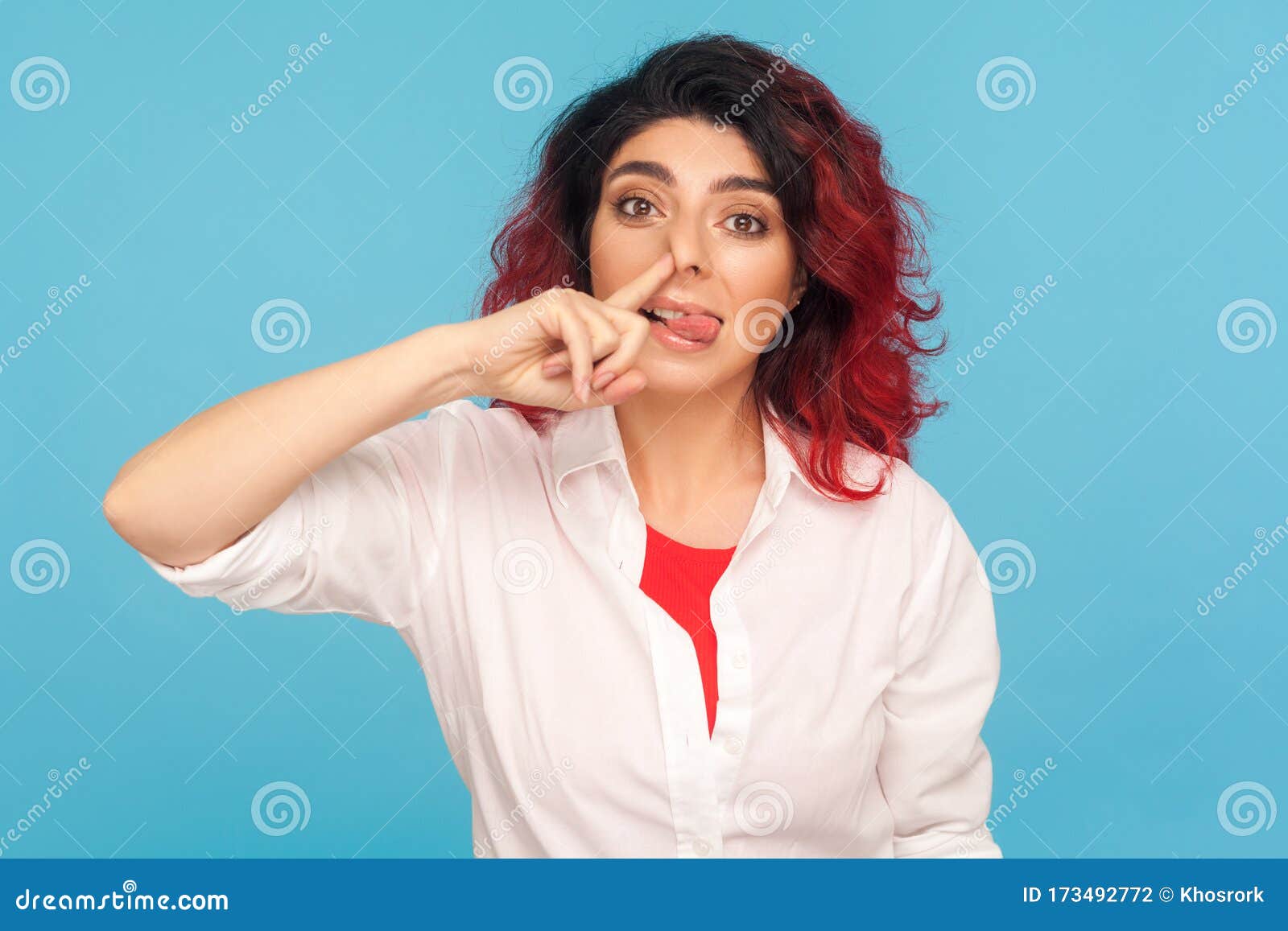 bad manners, misconduct. portrait of funny comical hipster woman with fancy red hair picking her nose