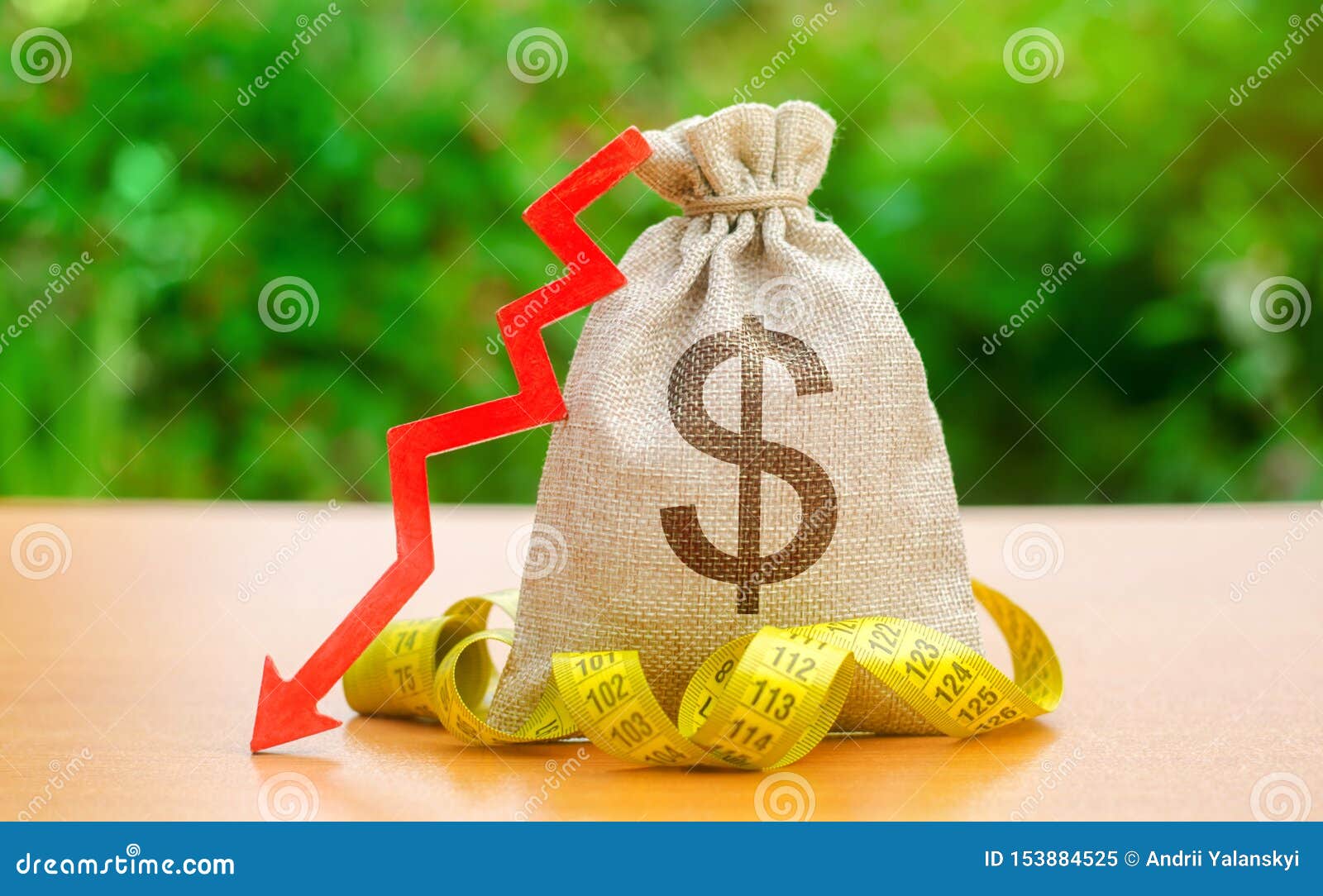bag with money and tape measure with arrow to down. falling wages and welfare. low profits and liquidity of investments. the