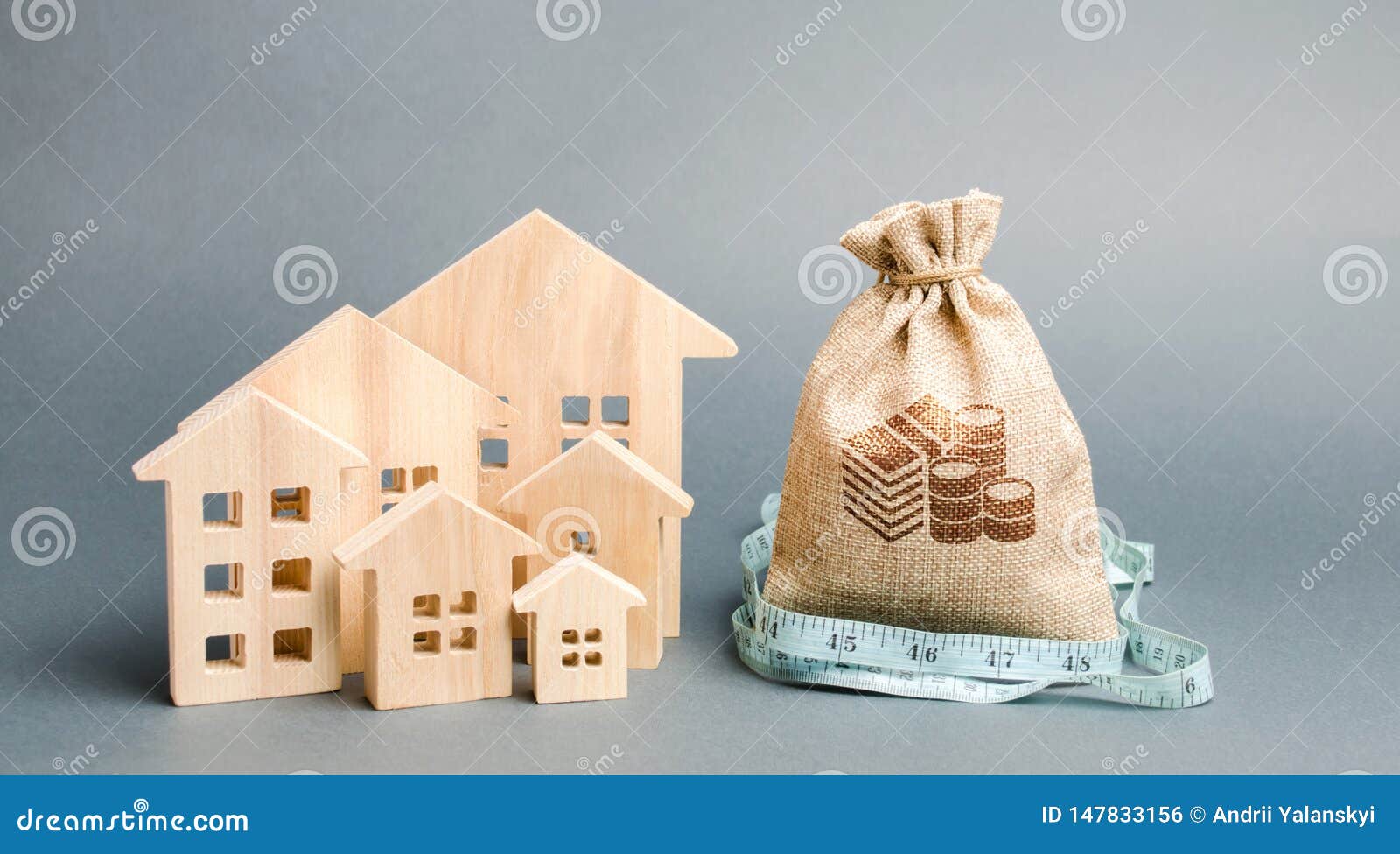 bag with money and tape measure with a wooden houses. the concept of a limited real estate budget. low subsidies. lack of