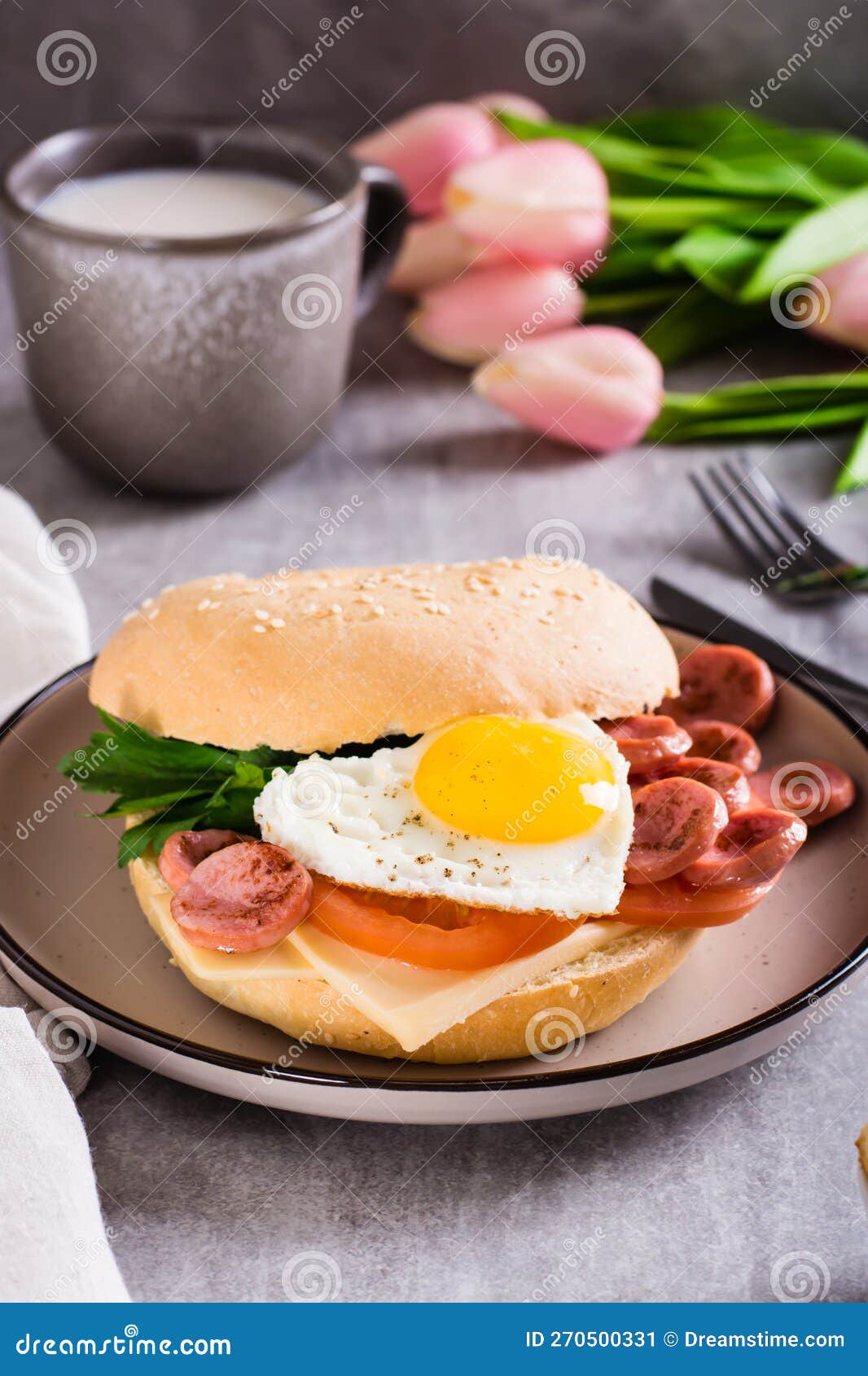 Bagel with Heartshaped Boiled Egg, Tomato, Cheese and Herbs on a Plate