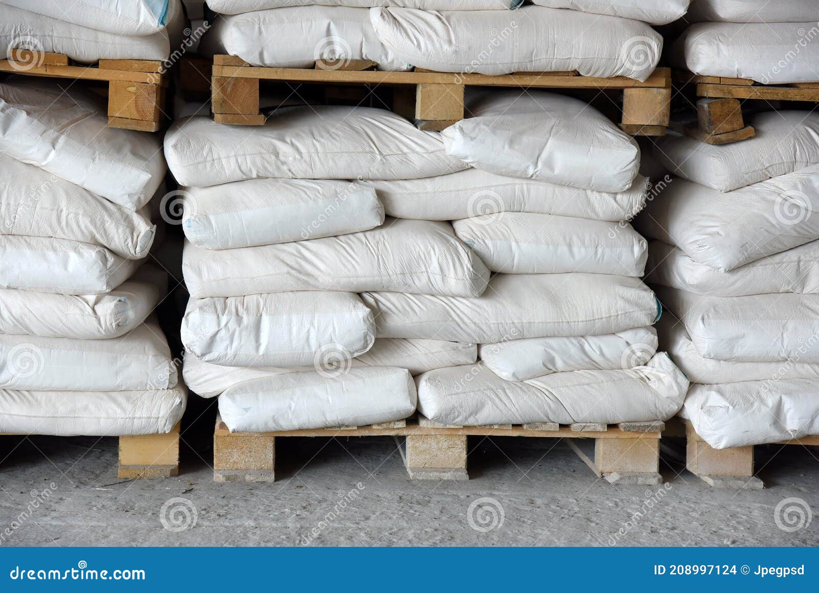 Bags of Cement in the Warehouse are Stacked on Pallets. Stock Photo
