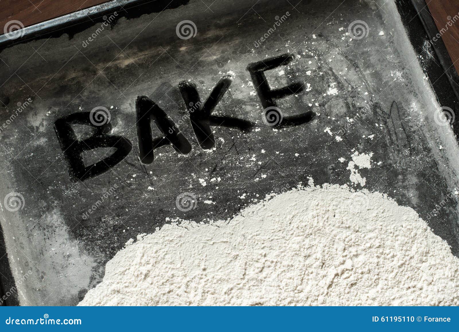 Bake Word Written on Baking Sheet Covered with White Flour Stock Photo