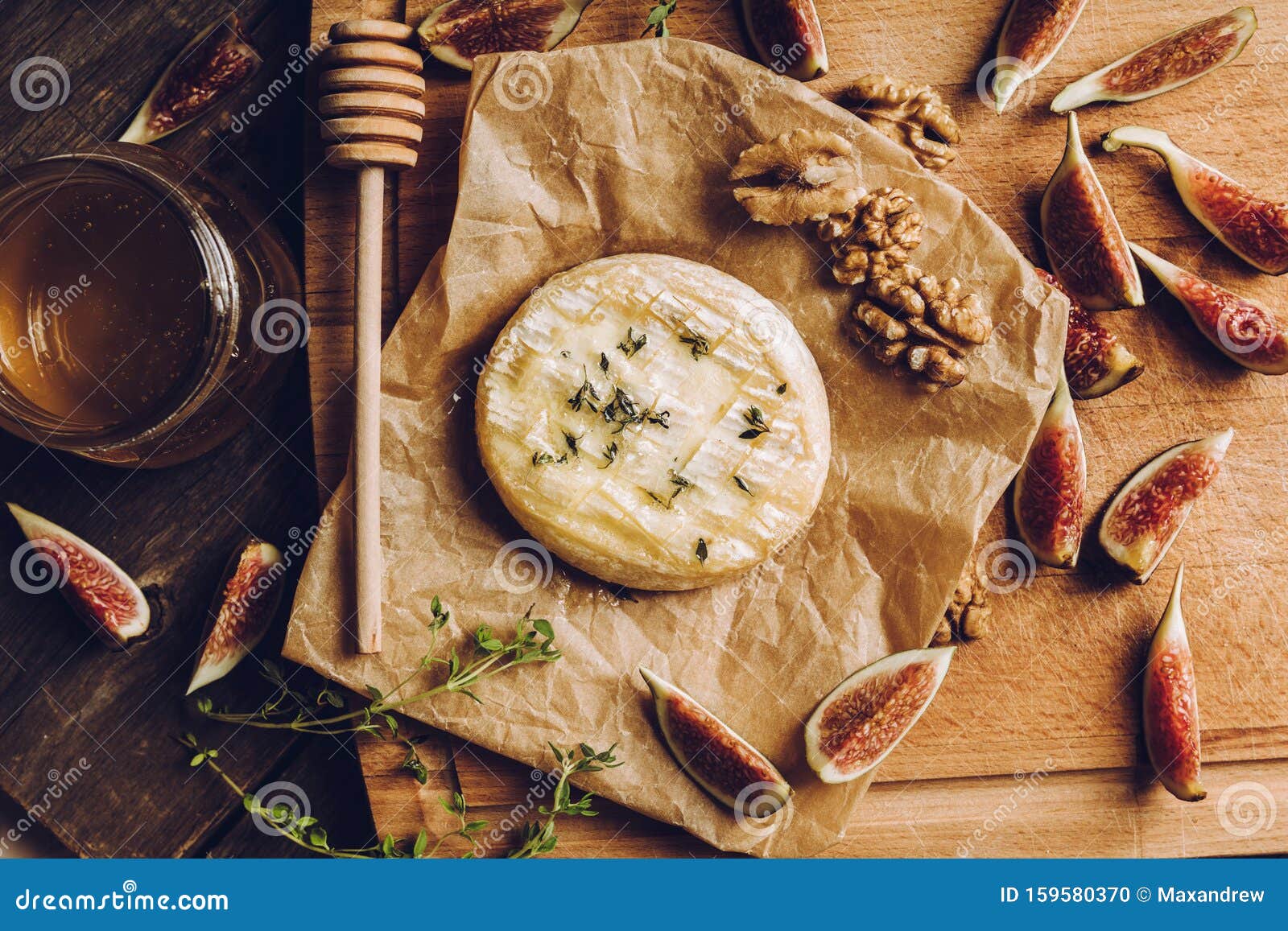baked camembert cheese with figs, walnuts, honey and thyme on the rustc background