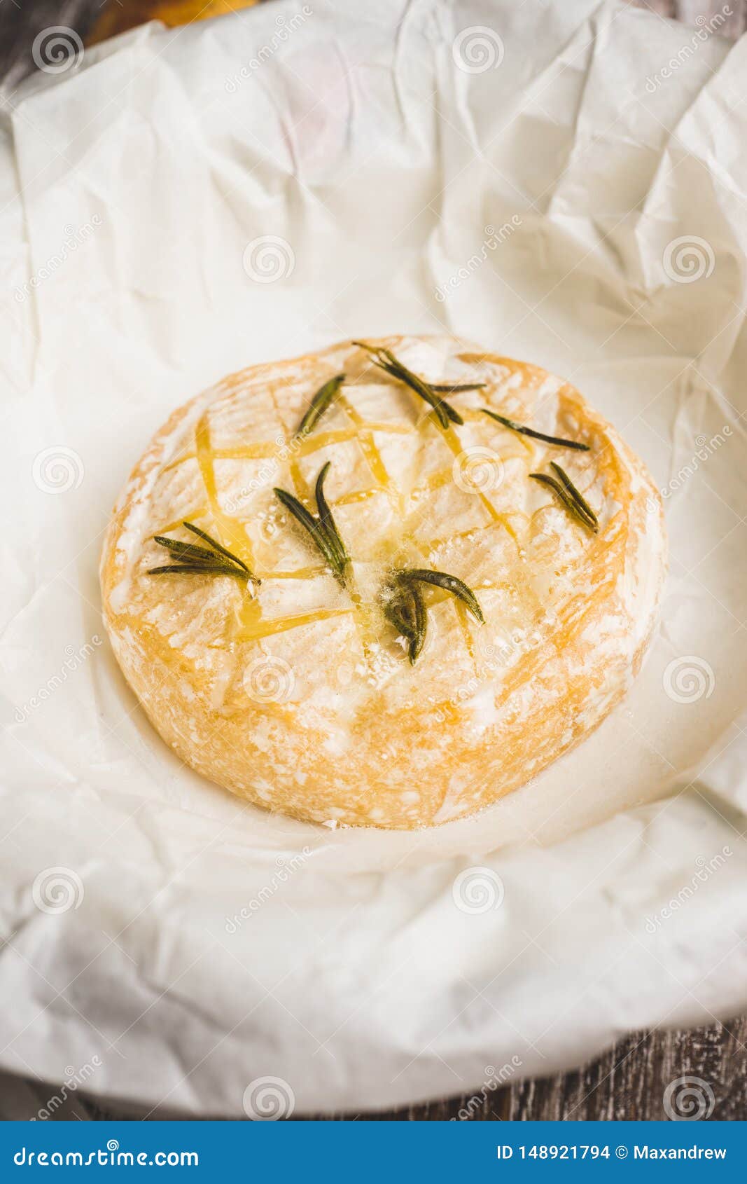 baked camembert cheese with toasts and rosemary herbs on the rustc background