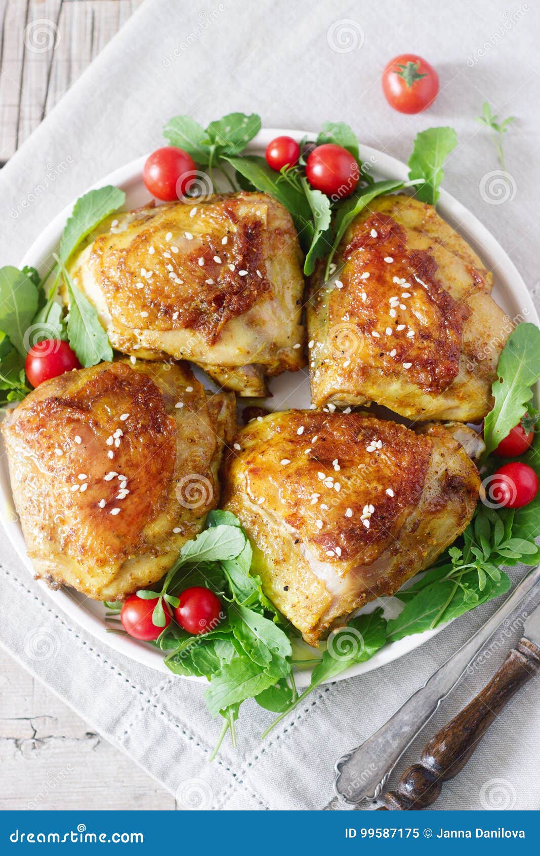 Baked Chicken Thighs with Garnish of Arugula and Tomatoes. Rustic Style